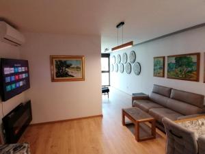 a living room with a couch and a tv at DOM LORON in Poreč