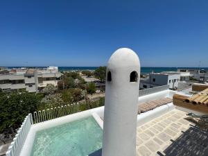 una piscina accanto a un palo bianco su un balcone di Casa Mediterranea con JACUZZI ,OSTUNI , vista Mare Torre Guaceto a Specchiolla