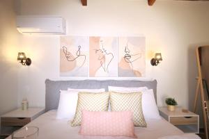 a bedroom with a bed with pink and white pillows at Dafnes in Skopelos Town