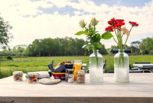 einen Tisch mit zwei Vasen und Blumen darauf in der Unterkunft Villa de Hazelaar in Schoorl
