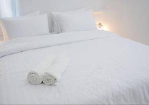 聖但尼的住宿－Majestics Luxury Apartments - 3BR With private Parking in front of train station - Paris Stade de France RER B，一张白色的床,上面有两条毛巾