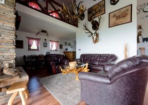 uma sala de estar com sofás de couro e uma mesa em Vila Pellegrini em Arandjelovac