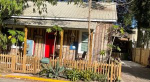 ein kleines Haus mit einem Holzzaun davor in der Unterkunft 150 year old Restored Lincolnville cottage in St. Augustine + 22 Fotos