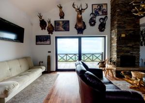 Vila Pellegrini في أراندجيلوفاك: غرفة معيشة مع أريكة وبعض القرون على الحائط