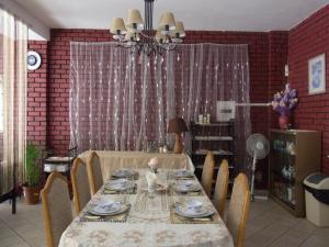 una sala da pranzo con tavolo, sedie e lampadario pendente di Bed and breakfast Newlife BNB a Edenvale