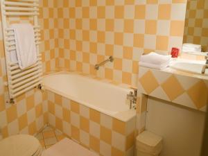 a bathroom with a bath tub and a sink at Hotel La Bougnate in Blesle