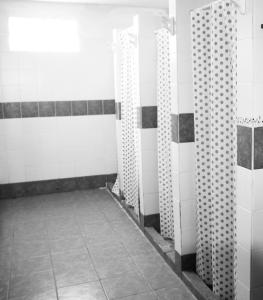 a bathroom with white and black walls and tile floors at Hostel Bahía Ballenas in Puerto Pirámides