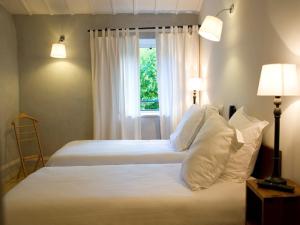 En eller flere senge i et værelse på Hotel La Bougnate