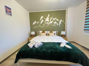 a bedroom with a bed with mountains on the wall at Tudor's Mountain Retreat in Campina