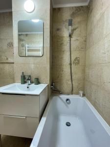 a bathroom with a white tub and a sink at Tudor's Mountain Retreat in Campina