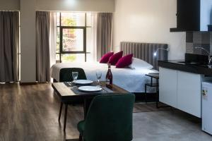 una camera con un letto e un tavolo con bicchieri da vino di Fiori Apartments a Santa Cruz de la Sierra Altre 63 foto