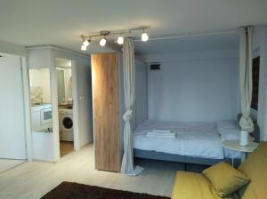 a bedroom with a bed and a living room at comfy condo Otopeni in Otopeni