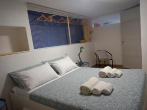 1 dormitorio con 1 cama con toallas en Vacanze Nella casetta en Pula