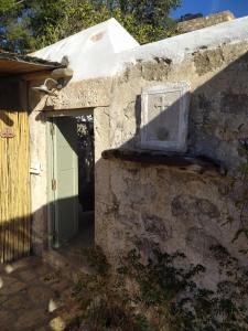 an entrance to a stone building with a green door at Latmos 1860 in Skala