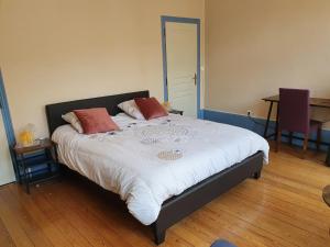 a bedroom with a large bed with two pillows on it at La Cour des Marotiers in Mareuil-sur-Ay