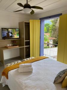 a bedroom with a bed with a ceiling fan at Pousada Relicário in Tiradentes