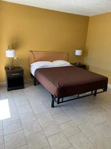 a bedroom with a bed with two night stands and two lamps at Budget Inn Decatur Priceville in Decatur
