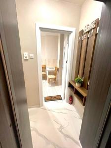 a hallway leading to a bathroom with a mirror at Home in Varna City