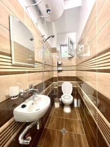 a bathroom with a white sink and a toilet at Home in Varna City