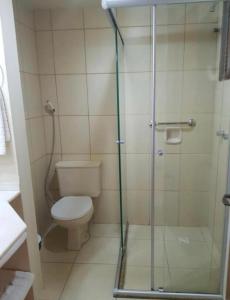a bathroom with a toilet and a glass shower at Pousada do Serrano - Rua Torta in Gramado