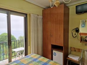 1 dormitorio con 1 cama y balcón en Pensión Tximistarri, en San Sebastián
