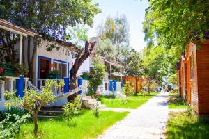 una calle en un pueblo con casas y árboles en Naz Beach Bungalow Hotel in Antalya, en Kızılot