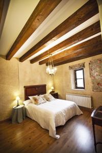 a bedroom with a large bed and a chandelier at Posada Real del Buen Camino in Villanueva de Campeán