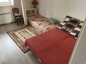 a bedroom with two beds and a red rug at Stanica Rowerowa Wygnanki in Wygnanki