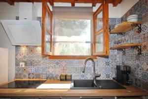 a kitchen with a sink and a window at Dafnes in Skopelos Town +53 photos