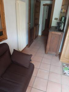uma sala de estar com um sofá e piso em azulejo em Casa Elena em Nus