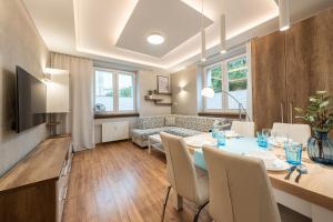 - une salle à manger et un salon avec une table et des chaises dans l'établissement Apartment BlueBird Katowice near Spodek MCK & City Center, à Katowice