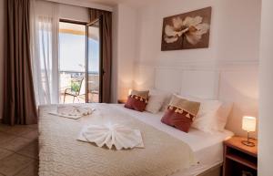 a bedroom with a large white bed with a window at Matej in Budva