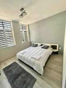 a bedroom with a large white bed and two windows at Dream in Varna City