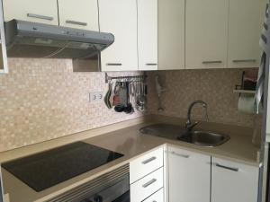 a kitchen with white cabinets and a sink at Casa Barbara El Cotillo in Cotillo