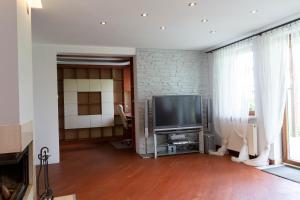 a living room with a television and a brick wall at Ancoba House in Łomna