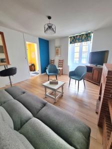 a living room with a couch and chairs and a table at Gîte la Libellule 4 couchages 15 min du Puy du Fou in Saint-Amand-sur-Sèvre