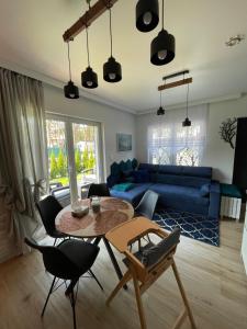 a living room with a table and a blue couch at Blue Wave Garden in Dziwnówek