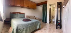 um quarto com uma cama e um sofá num quarto em Joneson aluga QUITINETE próximo a Praia do Forte até 4 pessoas em Cabo Frio