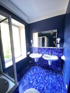 Baño azul con 2 lavabos y espejo en Castello mit Park, en Ponte Tresa