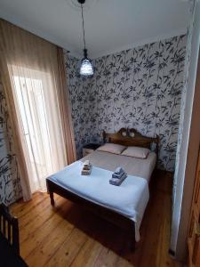 a bedroom with a bed and a black and white wallpaper at Kobuleti Guest House in K'obulet'i
