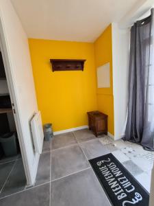 Habitación con pared amarilla y suelo en Gîte la Libellule 4 couchages 15 min du Puy du Fou en Saint-Amand-sur-Sèvre
