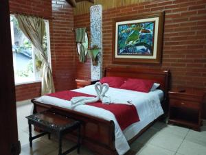 a bedroom with a bed with a bow on it at Hostal Casa Cultural Mindo in Mindo