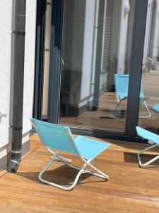 einem blauen Klappstuhl auf einem Holzboden in der Unterkunft Brand New 2 bedrooms with Parking and Terrace - 142-96 in Luxemburg (Stadt)