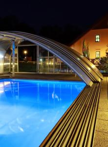a pool in front of a house at night at Wellness Penzion Pod Rozhlednou in Kostelec nad Orlicí