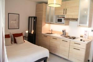 a small room with a bed and a kitchen at MARCO POLO - Studio privé avec piscine et parking in Mandelieu-La Napoule