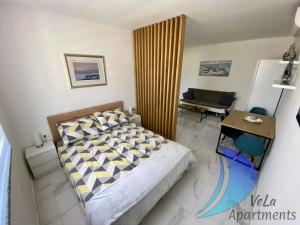 sypialnia z łóżkiem, stołem i kanapą w obiekcie VeLa Apartments w mieście Ičići
