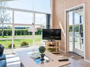 a living room with a large window and a tv at Three-Bedroom Holiday home in Tarm 5 in Hemmet
