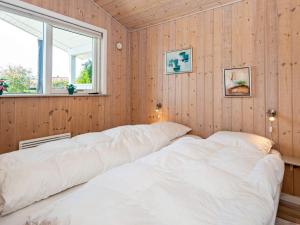 two beds in a room with wooden walls at Three-Bedroom Holiday home in Tarm 5 in Hemmet