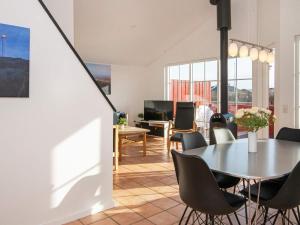 Three-Bedroom Holiday home in Hvide Sande 2 في Nørre Lyngvig: غرفة طعام مع طاولة وكراسي
