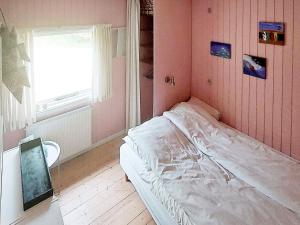 a small bedroom with a bed and a window at Two-Bedroom Holiday home in Aakirkeby 7 in Vester Sømarken
